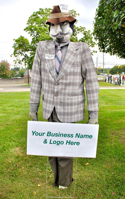 A scarecrow in a gray and white plaid jacket is wearing a brown hat with a tag that says "Press Pass." The scarecrow has a black and white face and is standing in front of a sign with text that reads: "Your Business Name & Logo Here."